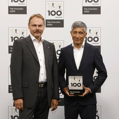 TOP100 Siegerehrung: Ranga Yogeshwar (rechts) gratuliert Dr. Sergio Drawert (Technische Leitung RZB) beim Deutschen Mittelstands-Summit in Augsburg (Bildquelle: KD Busch / compamedia)